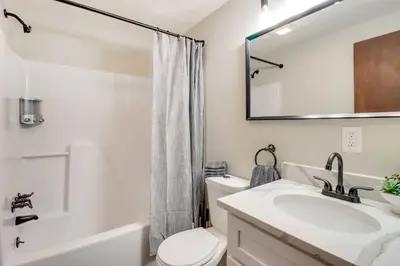 a bathroom with a sink and a toilet and a mirror at Chalet retreat in Tobyhanna in Tobyhanna
