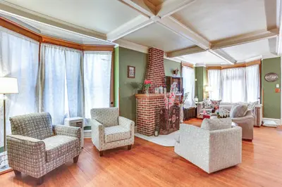 a living room with chairs and a couch and windows at Historic Home with Yard in the Heart of Reading! in Reading