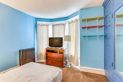 a bedroom with a bed and a television on a dresser at Historic Home with Yard in the Heart of Reading! in Reading