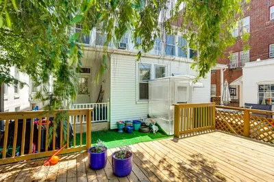 a backyard with a wooden deck and a house at Historic Home with Yard in the Heart of Reading! in Reading