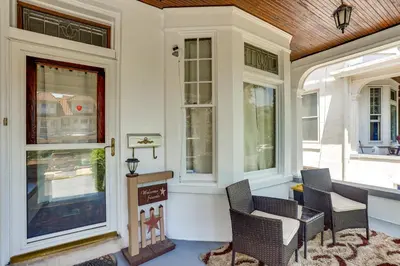 a porch with chairs and a table and windows at Historic Home with Yard in the Heart of Reading! in Reading