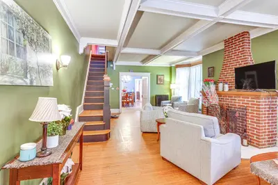 a living room with a staircase and green walls at Historic Home with Yard in the Heart of Reading! in Reading