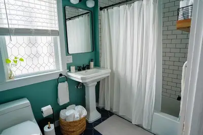 a bathroom with a white sink and a mirror at Stylish Apt Walk to Shops, Dining, and Bucknell in Lewisburg