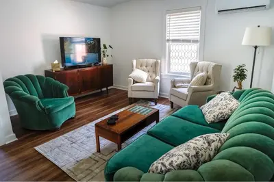 a living room with a green couch and two chairs at Stylish Apt Walk to Shops, Dining, and Bucknell in Lewisburg