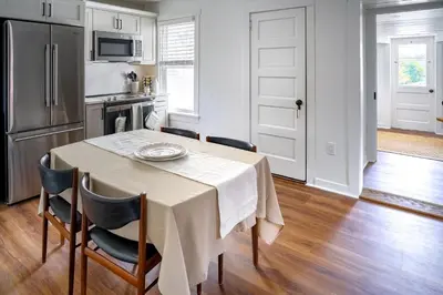 a kitchen with a table with chairs and a refrigerator at Stylish Apt Walk to Shops, Dining, and Bucknell in Lewisburg