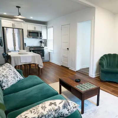 a living room with a green couch and a table at Stylish Apt Walk to Shops, Dining, and Bucknell in Lewisburg