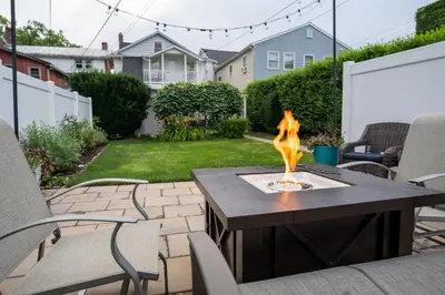 a patio with a table with a fire pit at Garden Retreat Steps from Downtown Lewisburg in Lewisburg