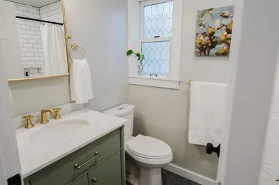 a bathroom with a sink and a toilet and a window at Garden Retreat Steps from Downtown Lewisburg in Lewisburg