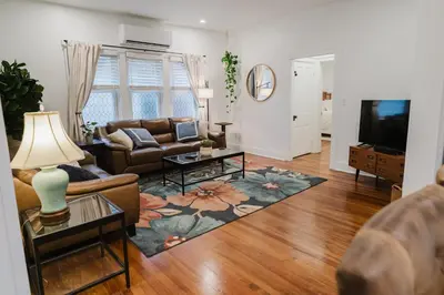 a living room with a couch and a tv at Garden Retreat Steps from Downtown Lewisburg in Lewisburg