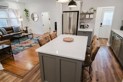 a kitchen and living room with a white counter top at Garden Retreat Steps from Downtown Lewisburg in Lewisburg