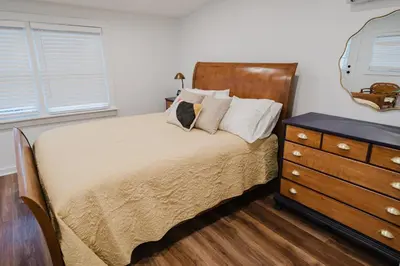 a bedroom with a bed and a dresser at Garden Retreat Steps from Downtown Lewisburg in Lewisburg