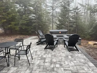 a patio with tables and chairs and a grill at The Hangout Haven - Theater, Hot tub, Pickleball, Ping pong, Firepit in Long Pond