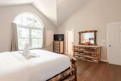 a bedroom with a white bed and a mirror at The Hangout Haven - Theater, Hot tub, Pickleball, Ping pong, Firepit in Long Pond