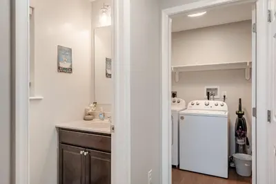 a bathroom with a sink and a washer and dryer at The Hangout Haven - Theater, Hot tub, Pickleball, Ping pong, Firepit in Long Pond