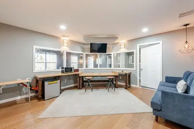a living room with a table and a blue couch at The Hangout Haven - Theater, Hot tub, Pickleball, Ping pong, Firepit in Long Pond