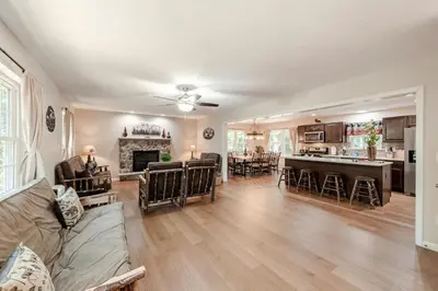 a living room with a couch and a kitchen at The Hangout Haven - Theater, Hot tub, Pickleball, Ping pong, Firepit in Long Pond