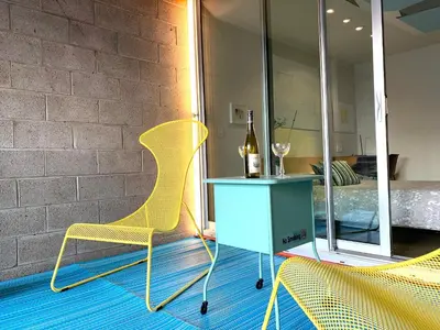 a yellow chair and a table with a bottle of wine at Loft Suite with private patio in Art Tower in Philadelphia