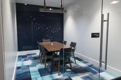 a dining room with a wooden table and chairs at Chique Loft 10 Min from NYC with Gym, Pool & Sauna in Jersey City