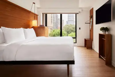 a bedroom with a white bed and a large window at Arlo SoHo in New York