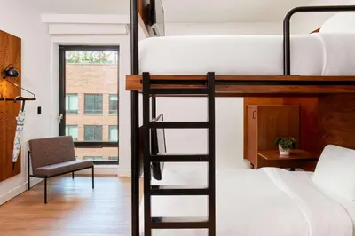 a bedroom with a bunk bed and a chair at Arlo SoHo in New York
