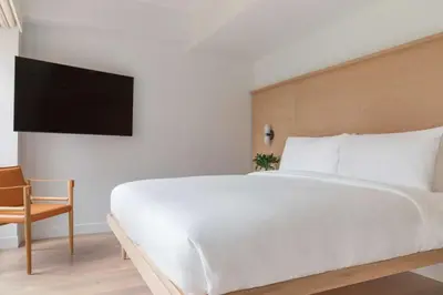 a bedroom with a large white bed and a chair at Arlo SoHo in New York