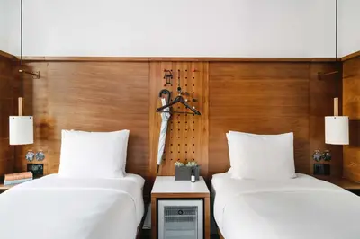 two beds in a room with wooden walls at Arlo SoHo in New York