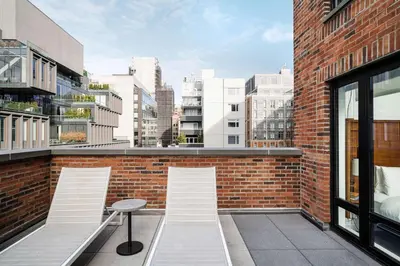 a balcony with two chairs and a table on a brick building at Arlo SoHo in New York