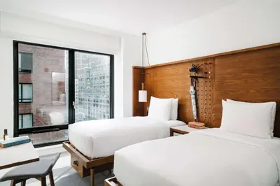two beds in a hotel room with a window at Arlo SoHo in New York