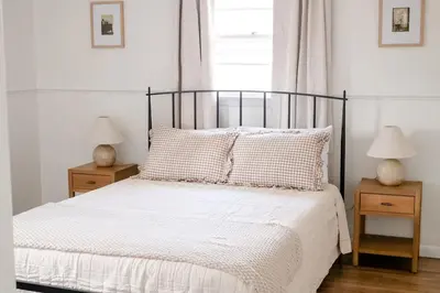 a bedroom with a bed with two nightstands and two lamps at Wooded Cottage in Elizabethtown with hot tub and sauna in Elizabethtown