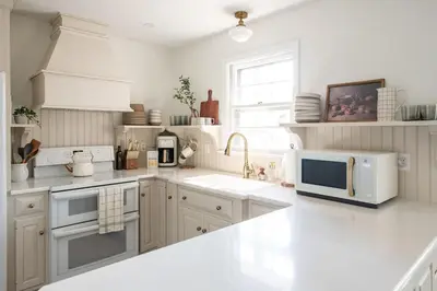 a white kitchen with a microwave and a sink at Wooded Cottage in Elizabethtown with hot tub and sauna in Elizabethtown