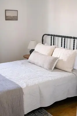 a bedroom with a bed with white sheets and pillows at Wooded Cottage in Elizabethtown with hot tub and sauna in Elizabethtown
