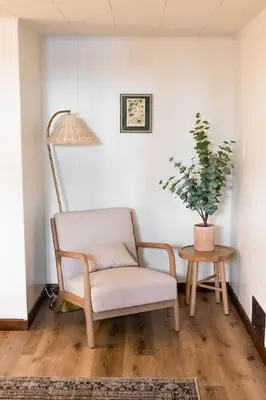 a chair and a table in a room with a potted plant at Wooded Cottage in Elizabethtown with hot tub and sauna in Elizabethtown