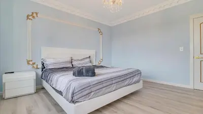 a white bedroom with a bed and a chandelier at VIP Mansion Estate in Blakeslee