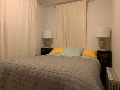 a bedroom with a large bed with two lamps at NYC Apartment by the Harbor in Saint George