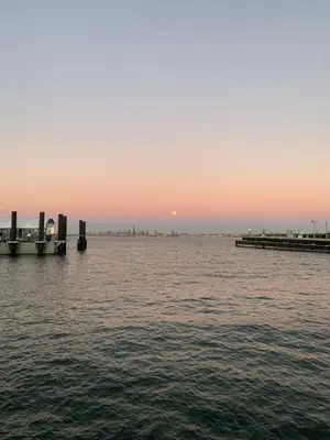 a sunset over a body of water with a pier at NYC Apartment by the Harbor in Saint George