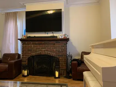 a living room with a fireplace with a television above it at NYC Apartment by the Harbor in Saint George