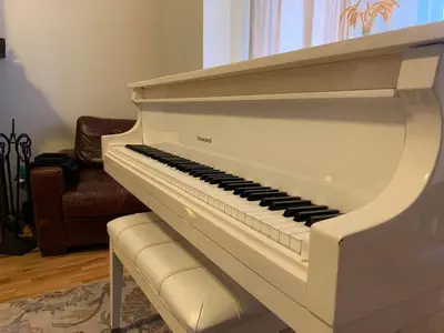 a white piano in a living room with a couch at NYC Apartment by the Harbor in Saint George