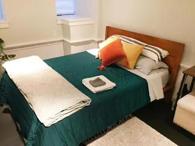 a bed with a green comforter with a plate on it at JC Moroccan Hideaway in Jersey City