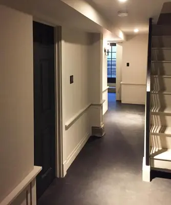 a hallway with stairs and a black door at JC Moroccan Hideaway in Jersey City
