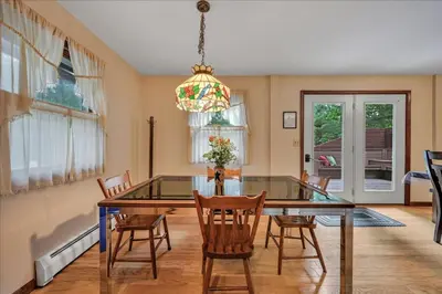 a dining room with a glass table and chairs at Swiss Chalet in Mount Gretna