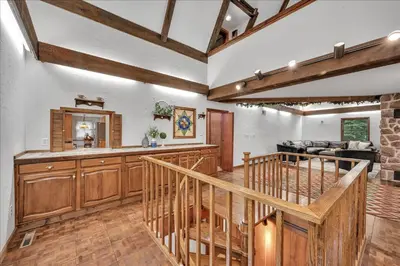 a large kitchen with wooden cabinets and a staircase at Swiss Chalet in Mount Gretna