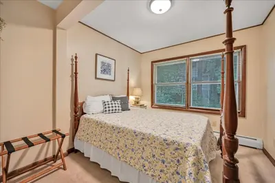 a bedroom with a bed and a large window at Swiss Chalet in Mount Gretna
