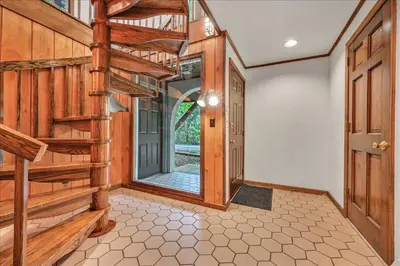 an empty hallway with wooden stairs and a door at Swiss Chalet in Mount Gretna