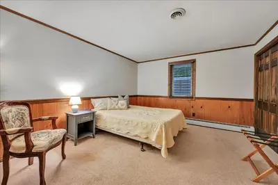 a bedroom with a bed and a desk and a chair at Swiss Chalet in Mount Gretna