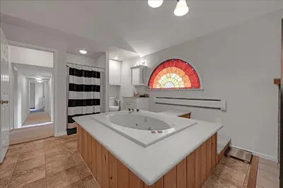 a white bathroom with a sink and a window at Muhlenberg Cottage in Mount Gretna