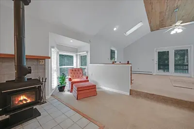 a living room with a fireplace and a chair at Muhlenberg Cottage in Mount Gretna