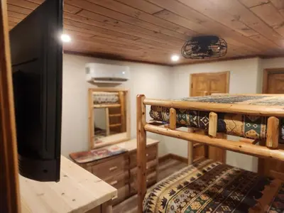 a room with two bunk beds and a flat screen tv at Pocono Mountain Retreat in Cresco