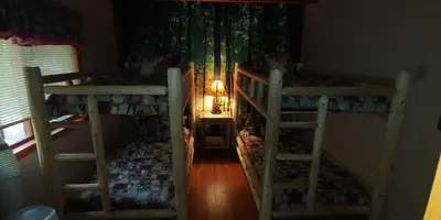 two bunk beds in a room with a lamp at Pocono Mountain Retreat in Cresco
