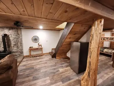 a living room with a vaulted ceiling and a refrigerator at Pocono Mountain Retreat in Cresco