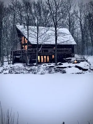 a log cabin with a snow covered roof at Pocono Mountain Retreat in Cresco